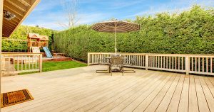 large Composite decking with an umbrella and a large patch of grass