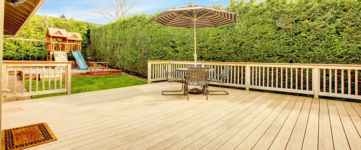 large Composite decking with an umbrella and a large patch of grass
